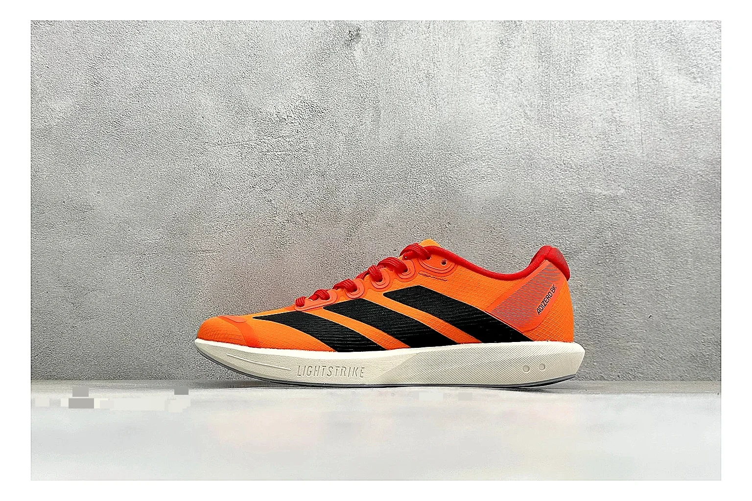 Adidas Adizero Orange Black spreadsheet record photo showing orange runner upper, black three-stripe contrast, lightweight racing shape, and thin performance sole