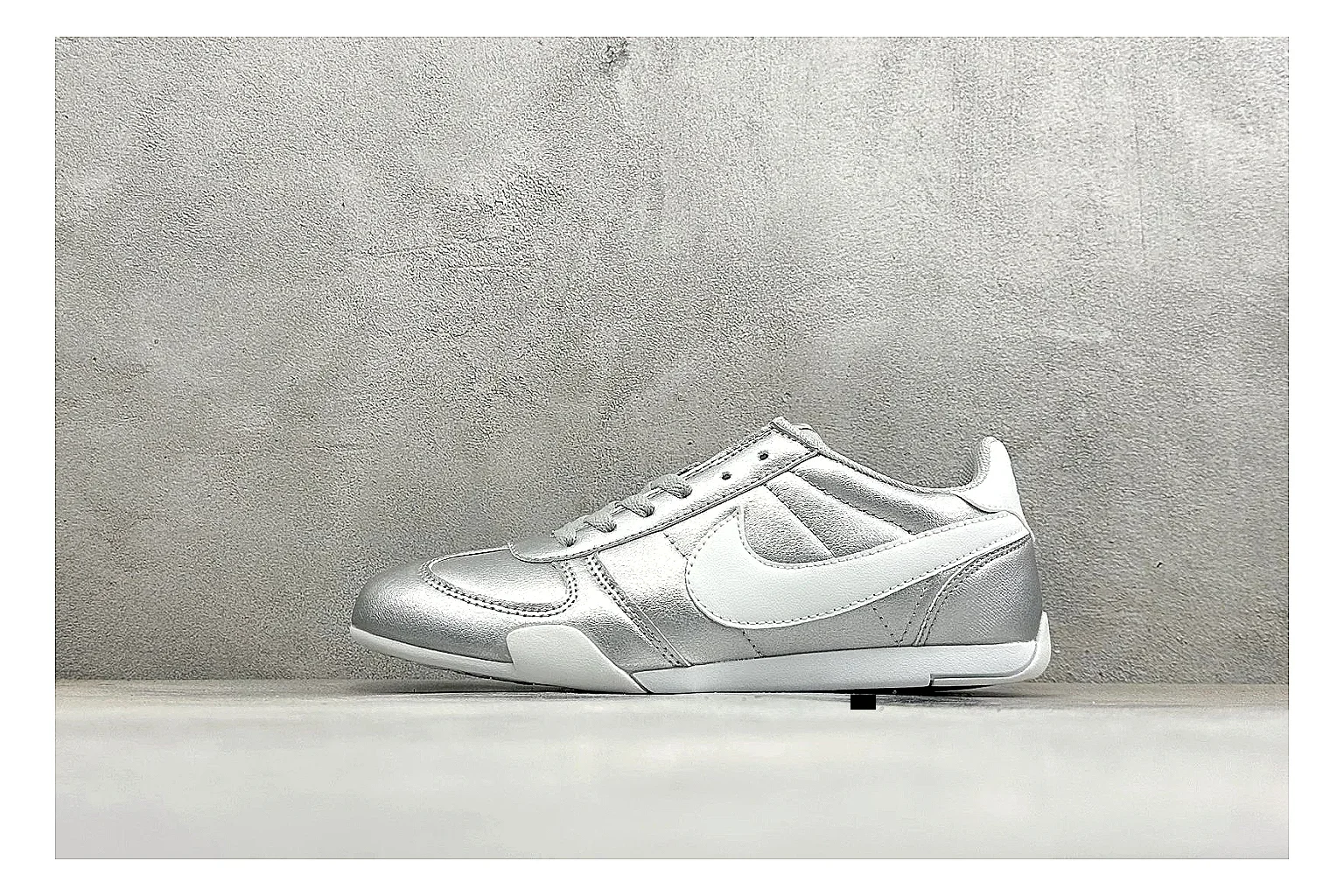 Nike Sprint Sister Silver spreadsheet record photo showing silver retro-runner upper, slim low-top shape, layered side panels, and a light everyday sole